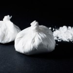 cocaine poured bag on black background