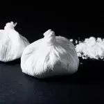 cocaine poured bag on black background