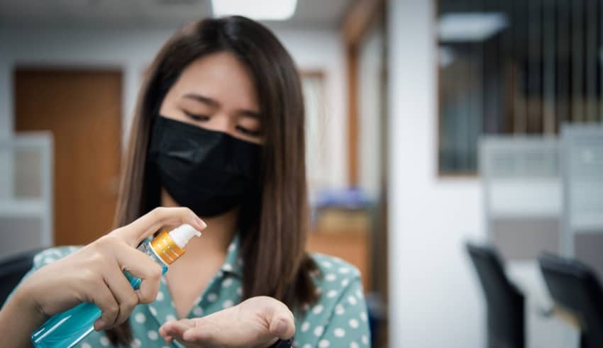 Asian woman wearing mask and alcohol antibacterial hand gel