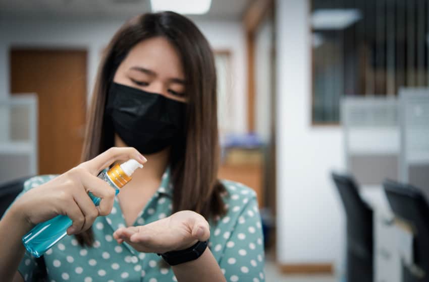 Asian woman wearing mask and alcohol antibacterial hand gel