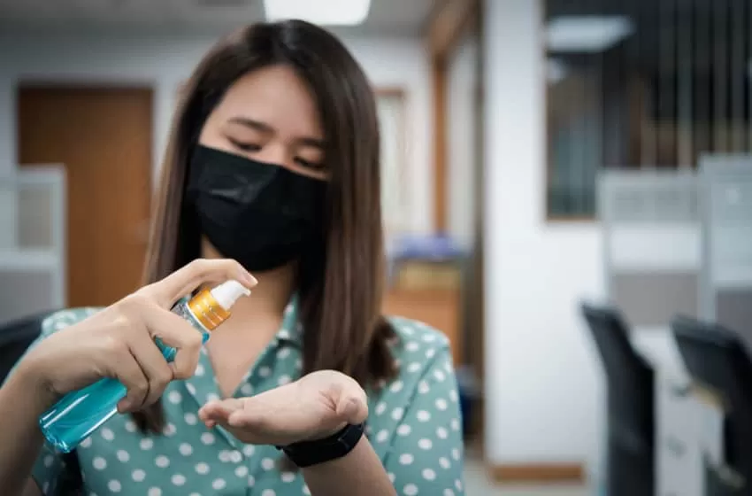 Asian woman wearing mask and alcohol antibacterial hand gel
