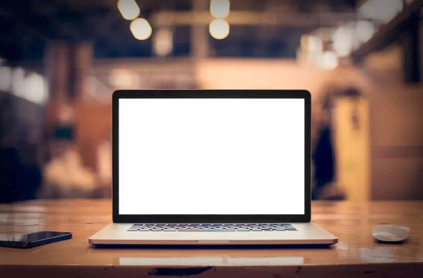 Laptop with blank screen on table