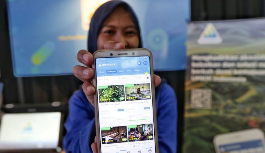 A woman shows fintech application Ammana on her smartphone