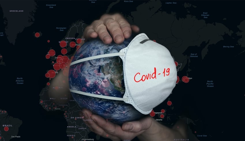 Female hands hold the Earth in a medical protective mask on the background of a map