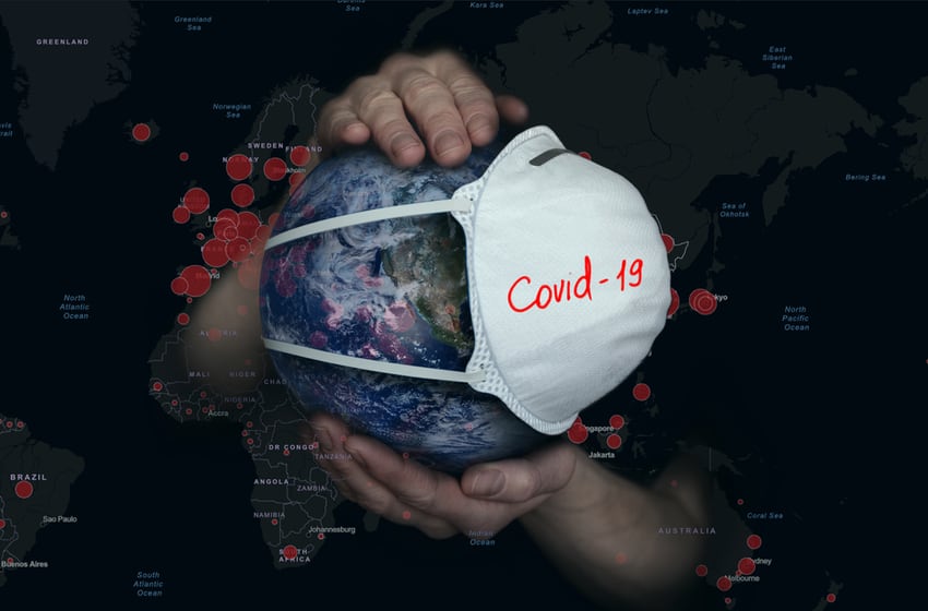 Female hands hold the Earth in a medical protective mask on the background of a map