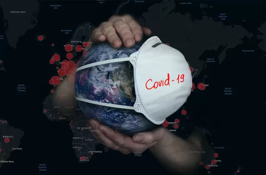 Female hands hold the Earth in a medical protective mask on the background of a map