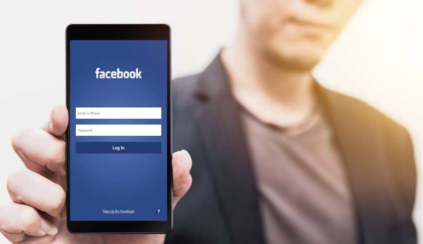 man show Facebook login page on his smartphone for using phone social app